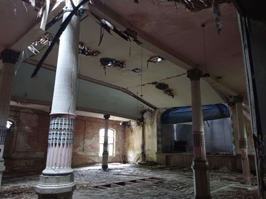 Large derelict dance hall with tall decorative pillars